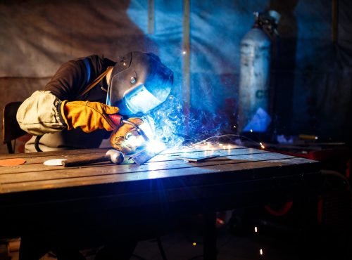 Worker cutting metal with plasma equipment. on plant